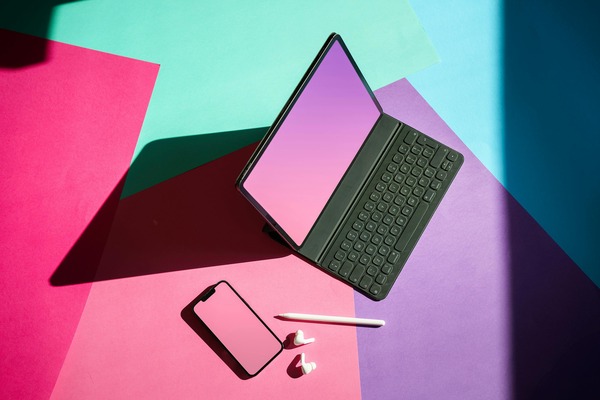 Colorful desk with colorful screen on laptop and smartphone and earbuds